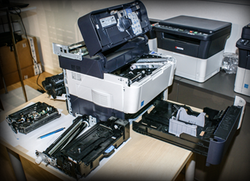 Monochromatyczna drukarka laserowa Kyocera FS-4200DN z wymontowanymi podzespołami; nasz poligon doświadczalny umożliwiający prezentację technologii druku laserowego. Urządzenie to jest typowym przedstawicielem współczesnych biurowych drukarek laserowych formatu A4. Nominalna rozdzielczość druku wynosi 1200 dpi, szybkość druku do 50 stron na minutę. Czas, od momentu otrzymania zadania wydruku do wydrukowania pierwszej strony to ok. 9 sekund, do tego ewentualnie trzeba doliczyć ok. 20 sekund na rozgrzanie drukarki, jeżeli nie była wcześniej używana. Cechą wyróżniającą ten model, jak i pozostałe drukarki laserowe japońskiej firmy Kyocera jest opatentowany bęben z powłoką ceramiczną, co oznacza znacznie wyższą wytrzymałość tego elementu. Producent gwarantuje od 100 000 do 600 000 wydruków (w zależności od modelu; w przypadku FS-4200DN gwarantowana wydajność bębna to 500 000 stron). Dopiero po takiej ilości wydrukowanych stron bęben może wymagać wymiany.